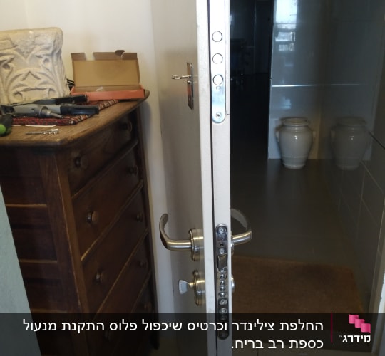 דלת פתוחה עם מנעול ומברגים על שידה